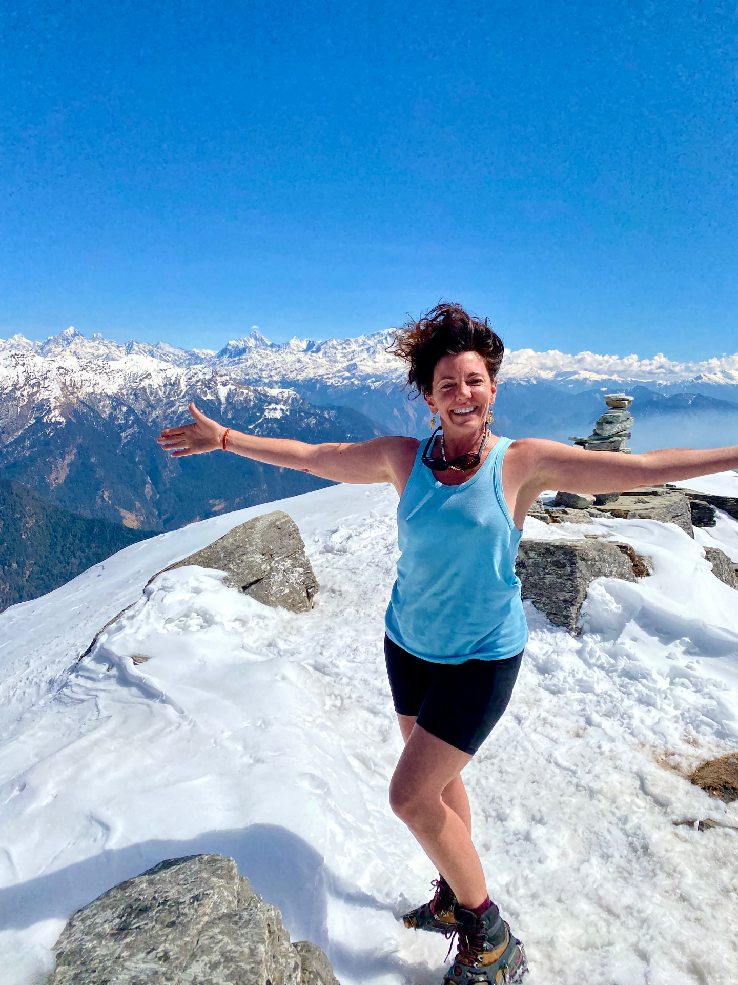 Natasha on a snowy Himalayan summit, arms wide