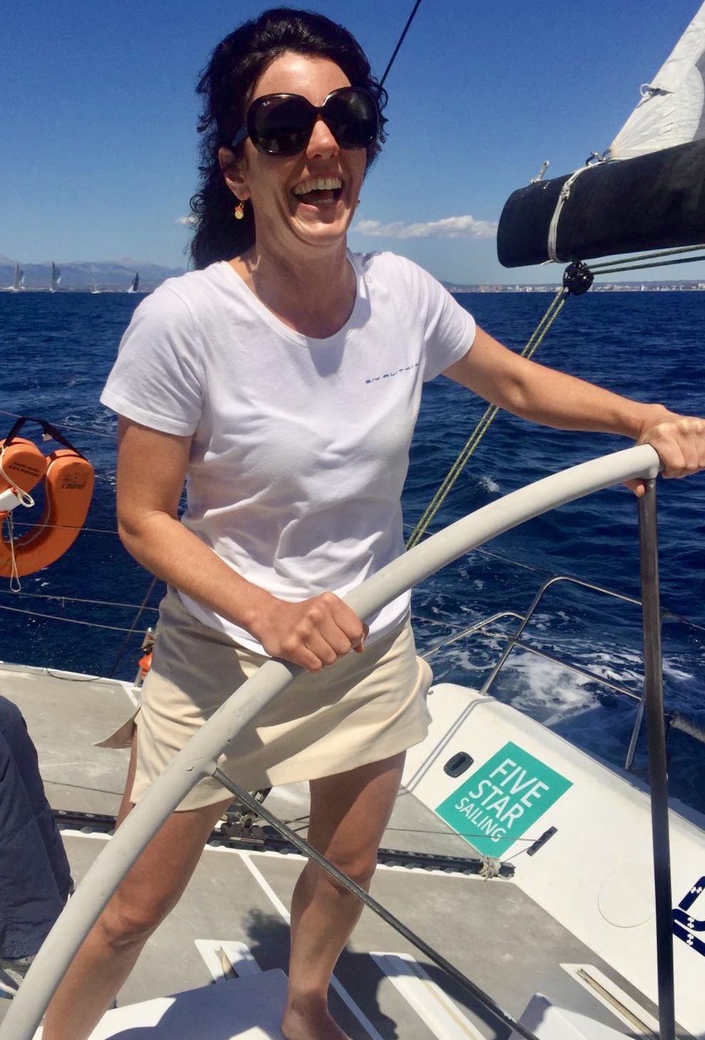 Natasha at the helm of a yacht at sea