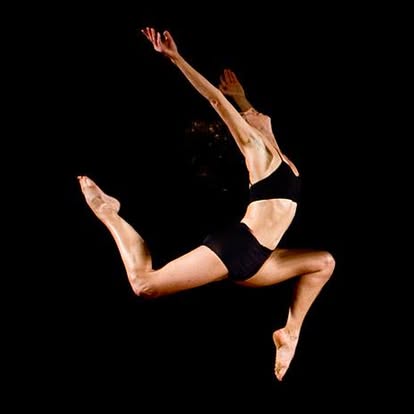 Natasha leaping in a studio against black