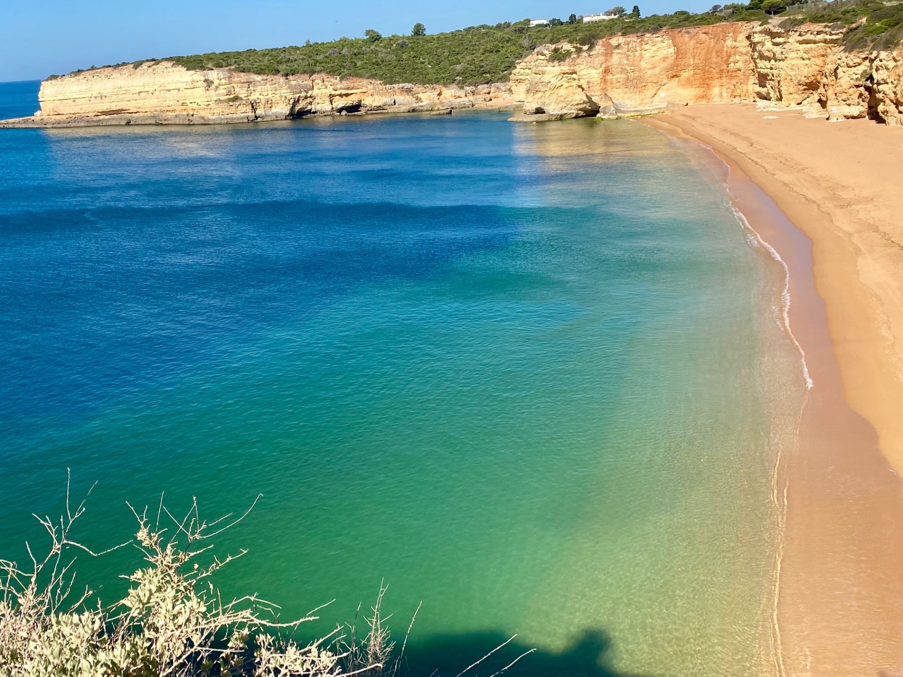 Sweeping turquoise bay with golden cliffs and empty sand beach, Algarve, Portugal