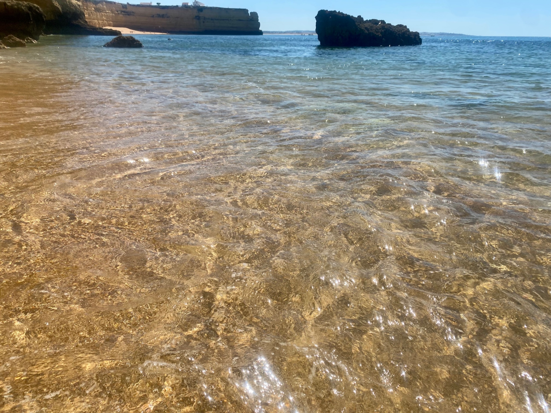 Crystal clear shallow water over golden sand at an Algarve cove, Portugal